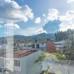 Blick auf eine Stadt mit Gebäuden und Bergen in der Unterkunft Primavera Plus in Villavicencio