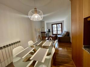 Un comedor con mesas blancas y sillas blancas. en BPIRINEOS-Parque Los Tilos 3, en Benasque