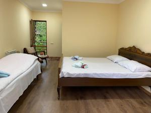 - une chambre avec 2 lits, une table et une fenêtre dans l'établissement Dilbo House, à Dilidjan