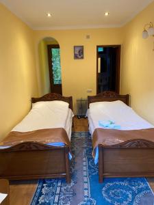 - 2 lits dans une chambre aux murs jaunes dans l'établissement Dilbo House, à Dilidjan