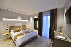 - une chambre avec un grand lit blanc et un bureau dans l'établissement La Dependance Luxury Bed and Breakfast, à Fondi