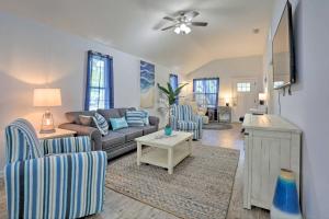 ein Wohnzimmer mit einem Sofa, Stühlen und einem Tisch in der Unterkunft St Augustine Beach Cottage Walk to Water! in St. Augustine