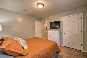 1 dormitorio con 1 cama y vestidor con TV en Comfy West Plains Home Less Than 1 Mi to Main Street! en West Plains