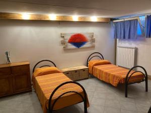 Habitación con 2 camas y una pintura en la pared. en Parco Vacanze La Rosa dei Venti, en Marina di Bibbona