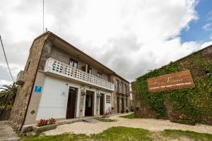 um edifício antigo com um sinal em frente em Ecocasa Lema II em Muxia