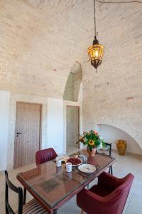 阿爾貝羅貝洛的住宿－Lamia Mari'- Aia Piccola，一间带木桌和红色椅子的用餐室