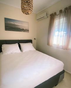 sypialnia z białym łóżkiem i oknem w obiekcie Elena apartment chalkidiki w mieście Kallithea