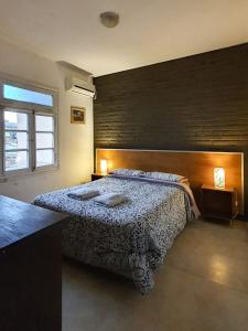 um quarto com uma cama e uma parede de tijolos em Hostel Carlos Gardel em Buenos Aires