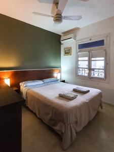 a bedroom with a bed with two towels on it at Hostel Carlos Gardel in Buenos Aires