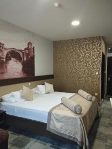 1 dormitorio con 1 cama y una pintura en la pared en Hotel Hercegovina en Mostar