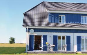 a blue and white house with a porch at Ferienhaus 3 Altefähr in Altefähr