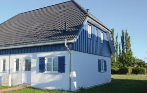 a white house with a blue roof at Ferienhaus 3 Altefähr in Altefähr