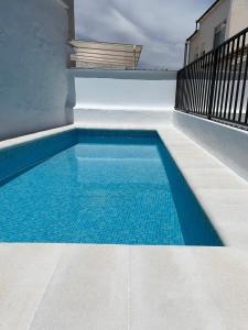 a swimming pool on the side of a house at Apartamento nuevo con piscina en el centro "Doña Paca" in Ronda