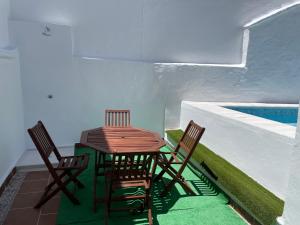 a table and chairs on a balcony with a swimming pool at Apartamento nuevo con piscina en el centro "Doña Paca" in Ronda