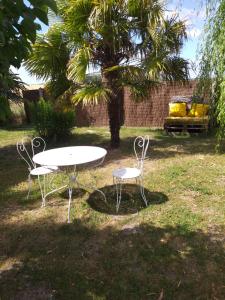 une table et deux chaises dans une cour avec un arbre dans l'établissement Chambres d'hôtes, " au coeur de la nature, et du calme", à Descartes