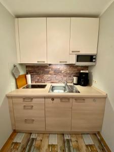 a kitchen with white cabinets and a sink at Landhaus Teuteberg in Bad Bevensen