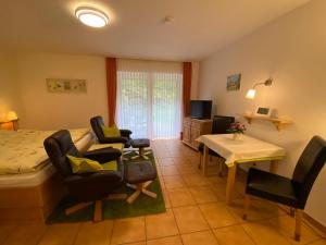 a bedroom with a bed and chairs and a table at Landhaus Teuteberg in Bad Bevensen