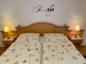 1 cama en un dormitorio con 2 lámparas en 2 mesas en Landhaus Teuteberg, en Bad Bevensen