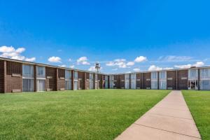 a large brick building with grass in front of it at Bricktown Hotel & Extended Stay in Oklahoma City