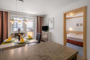 a hotel room with a bed and a dining table at Haus Voglreiter - inkl Sommerkarte, zentrale und ruhige Lage, Garten mit Spielplatz in Kaprun
