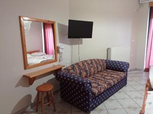 a living room with a couch and a mirror at Nikolitsa Apartments in Glyfada Fokidas