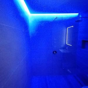 a blue light in a bathroom with a toilet at New Marina Apartments in Torri del Benaco +38 photos