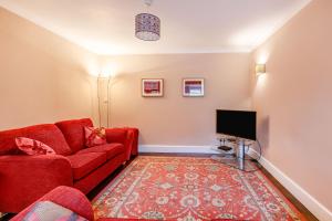 a living room with a red couch and a tv at 11 Beech Road in Weymouth