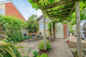 ein Garten mit Pergola, Tisch und Stühlen in der Unterkunft 11 Beech Road in Weymouth