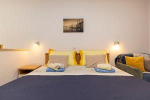 una camera da letto con un grande letto con cuscini gialli e blu di Villa Teresa a Mali Lošinj (Lussinpiccolo)