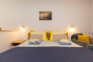 a bedroom with a large bed with yellow and blue pillows at Villa Teresa in Mali Lošinj +59 photos