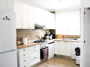 a kitchen with white cabinets and a stove top oven at La Pineda Calafell in Segur de Calafell