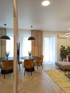 a dining room and living room with a table and chairs at [VerdeS] - Joyride Exclusive Apartment in Oradea