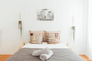 1 dormitorio con 1 cama con toallas en Coachella Vintage Chic in the Heart of St Charles Biarritz en Biarritz