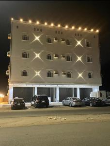 a large white building with cars parked in front of it at شقق الشاطئ in Al Qunfudhah