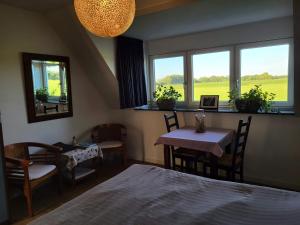 a bedroom with a bed and a table and chairs at Bed & Breakfast de Vink in Terschuur