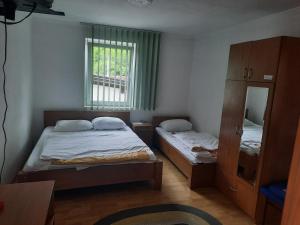 a small bedroom with two beds and a mirror at Motel Tetrijeb Sipovo in Šipovo