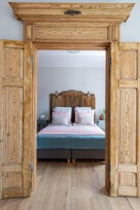 a bed with a wooden frame in a bedroom at Apartament Bulvar Premium Starówka in Elblag
