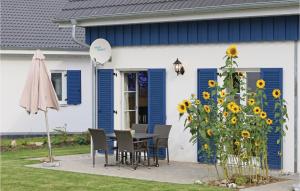 a table and chairs in front of a house with sunflowers at Ferienhaus 33 Altefähr in Altefähr