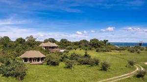 a field with a gazebo and the ocean at Konkamoya Lodge in Ngoma