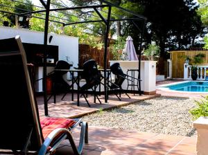 un patio con tavolo e sedie accanto alla piscina di La Pineda Calafell a Segur de Calafell