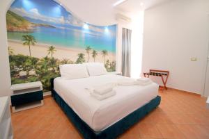 a bedroom with a large bed with a painting on the wall at Oskar Hotel in Sarand&euml;