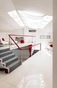 uma sala de estar com uma mesa de vidro e escadas em Vatican Modern Designer Loft em Roma