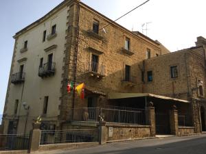 a large brick building with a flag in front of it at Sicily Rooms Enna in Enna