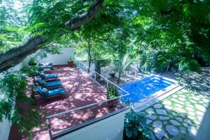 een patio met blauwe ligstoelen en een zwembad bij Villas Parota Inn in Nuevo Vallarta 