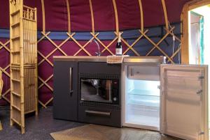 a kitchen with an open refrigerator and a stove at Orchard View Yurt & Hot Tub Somerset in Weston-super-Mare