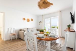 a dining room and living room with a table and chairs at Apartamento CASTELLSOL 309 by Mauter Villas in Arenal d'en Castell