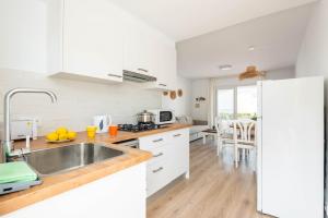 a kitchen with white cabinets and a stainless steel sink at Apartamento CASTELLSOL 309 by Mauter Villas in Arenal d'en Castell +14 photos