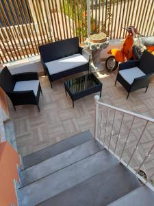 a patio with a couch and chairs and a scooter at Excelsior Mare Suite in Ischia