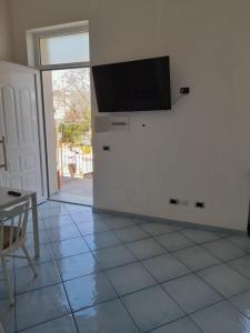 a living room with a tv and a tiled floor at Excelsior Mare Suite in Ischia