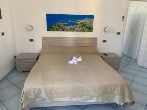 una camera da letto con un letto con un fiocco bianco di Excelsior Mare Suite a Ischia